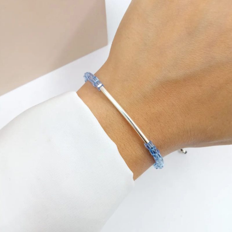 Pulsera regulable hilo negro con cristales celestes y tubo curvo de plata