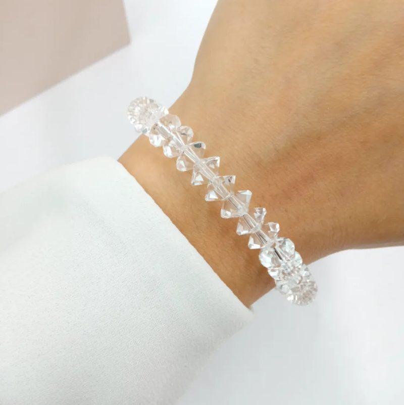 Anterior Siguiente PULSERA ELASTIZADA DE BICONO DE CRISTAL DE ROCA TRANSPARENTE